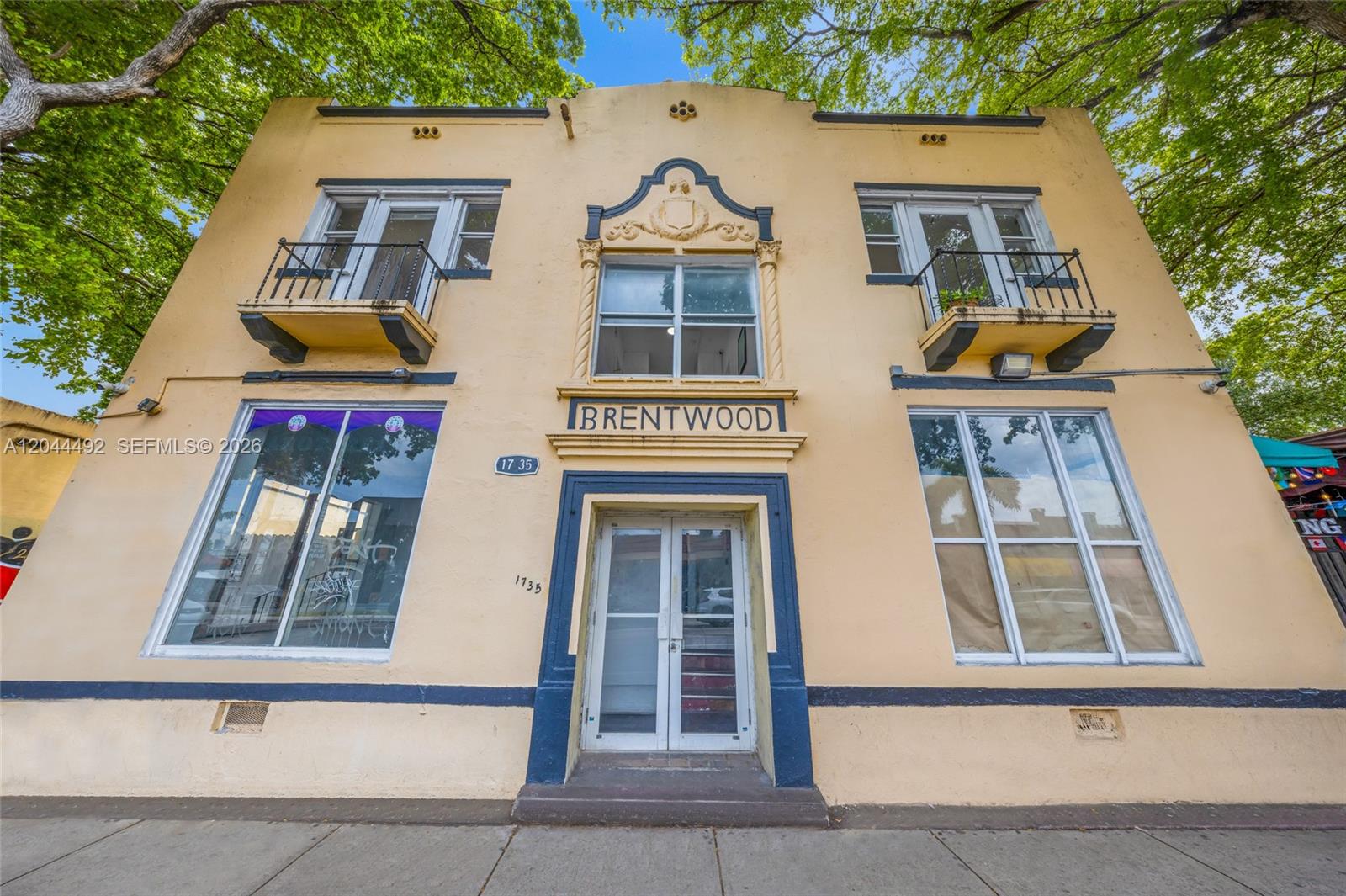 A two-story yellow stucco building features a central entrance, balconies, and large street-level windows — 1731 SW 8th St, Miami FL 33135, MIAMI, FL