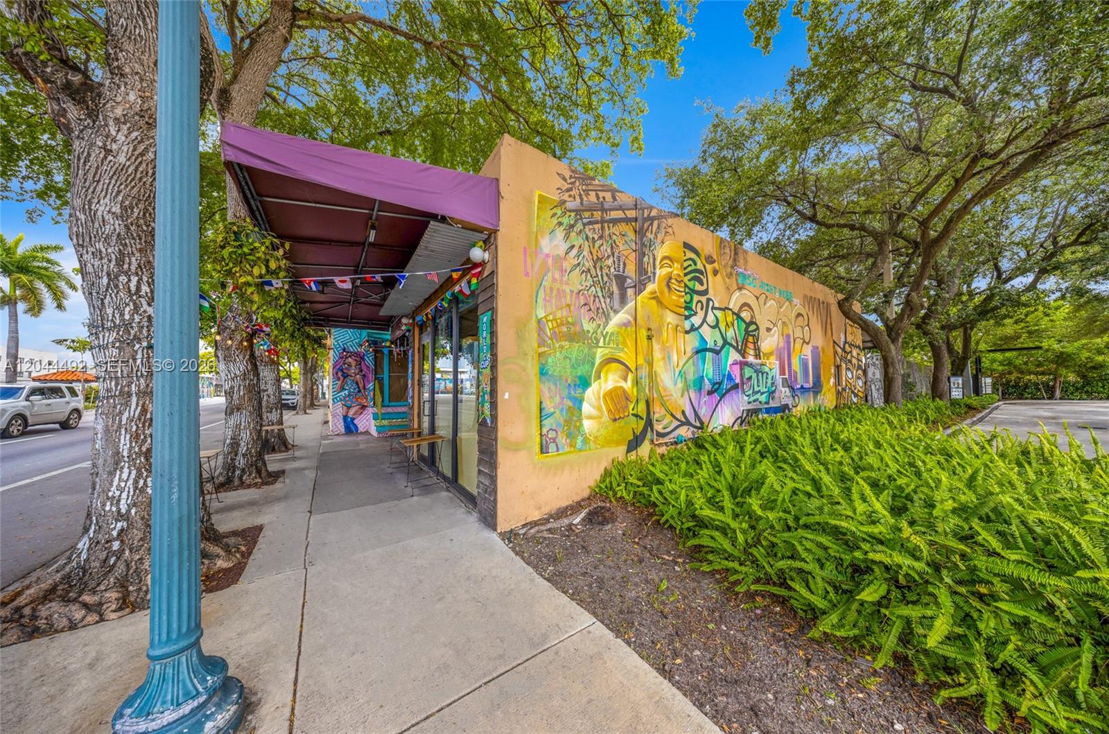 A building exterior features a large mural of a golden Buddha and a purple awning — 1731 SW 8th St, Miami FL 33135, MIAMI, FL