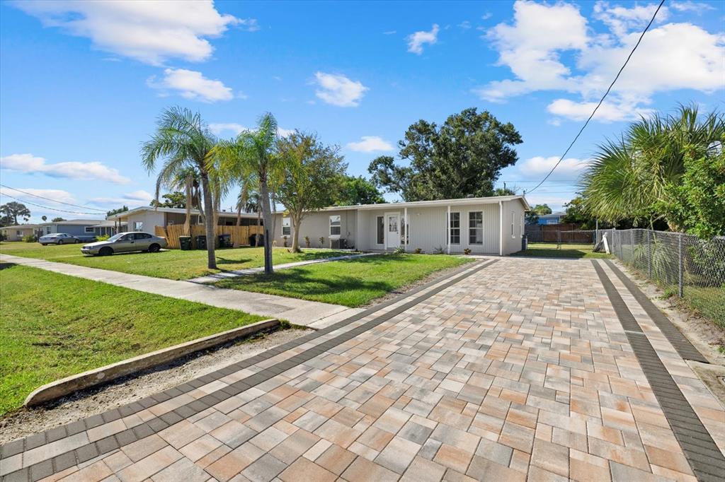 A single-story house with a paved driveway and palm trees under a blue sky — 6024 MERRIL STREET, NORTH PORT, FL