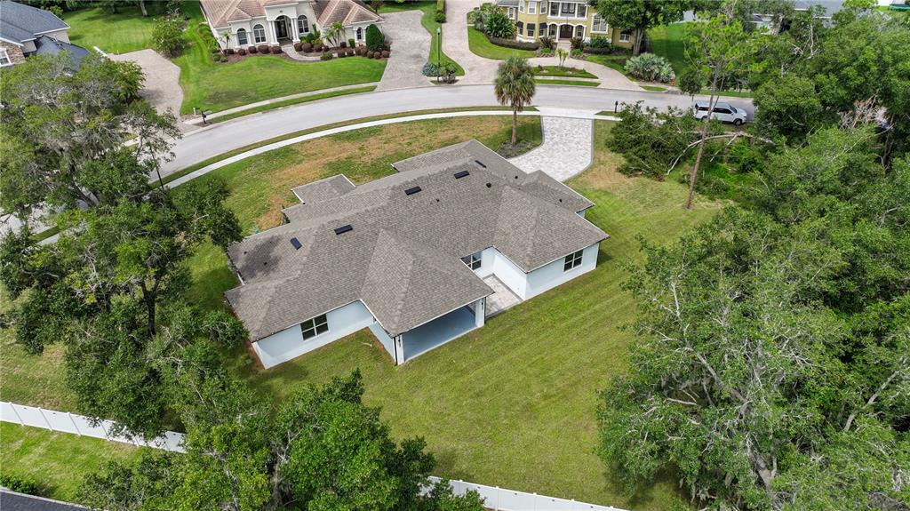 An aerial view of a single-story house with a gray roof and a paved driveway — 9531 MID SUMMER LANE, LEESBURG, FL