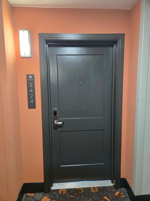 A dark gray door with a digital lock is set in a peach-colored wall — 14501 GROVE RESORT AVENUE UNIT 3424, WINTER GARDEN, FL