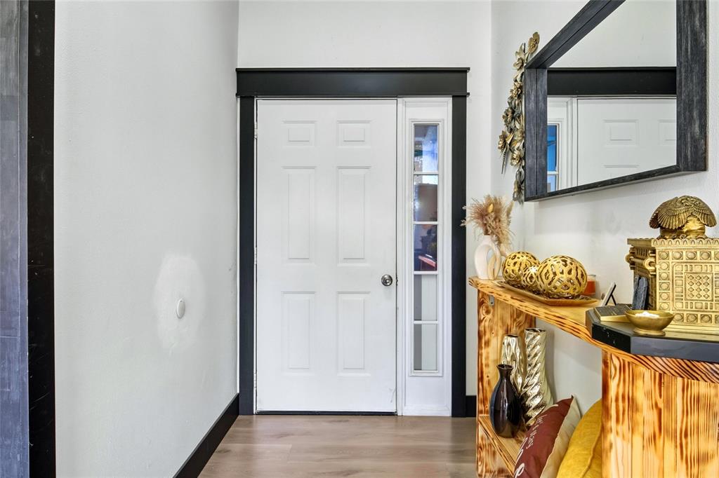 An entryway features a white door with black trim, a wood console table, and a mirror — 114 DUNDEE LANE, KISSIMMEE, FL
