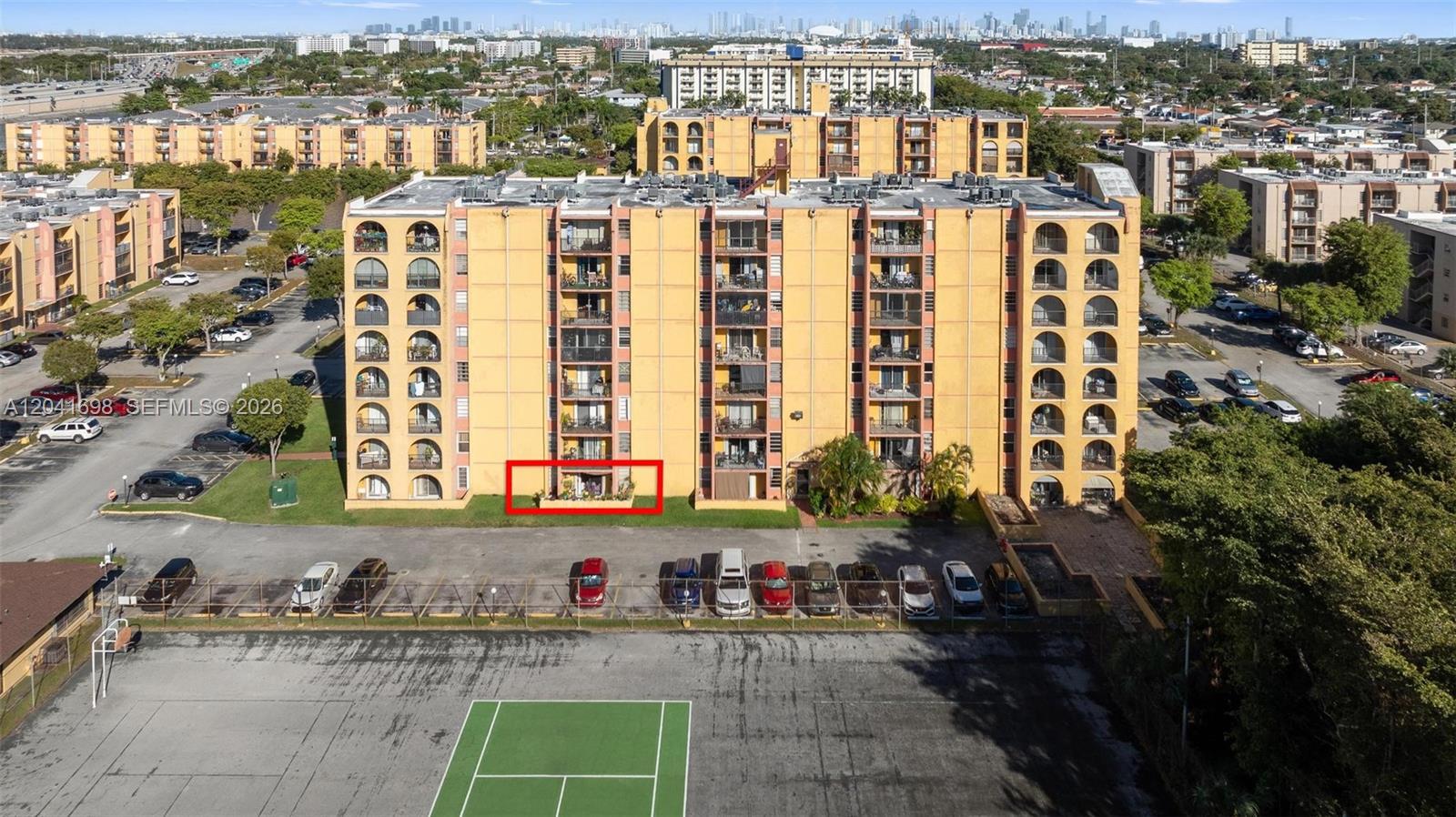 An aerial view shows a multi-story yellow apartment building with a red-outlined ground-floor patio — 4801 NW 7th St # 16, Miami FL 33126, MIAMI, FL