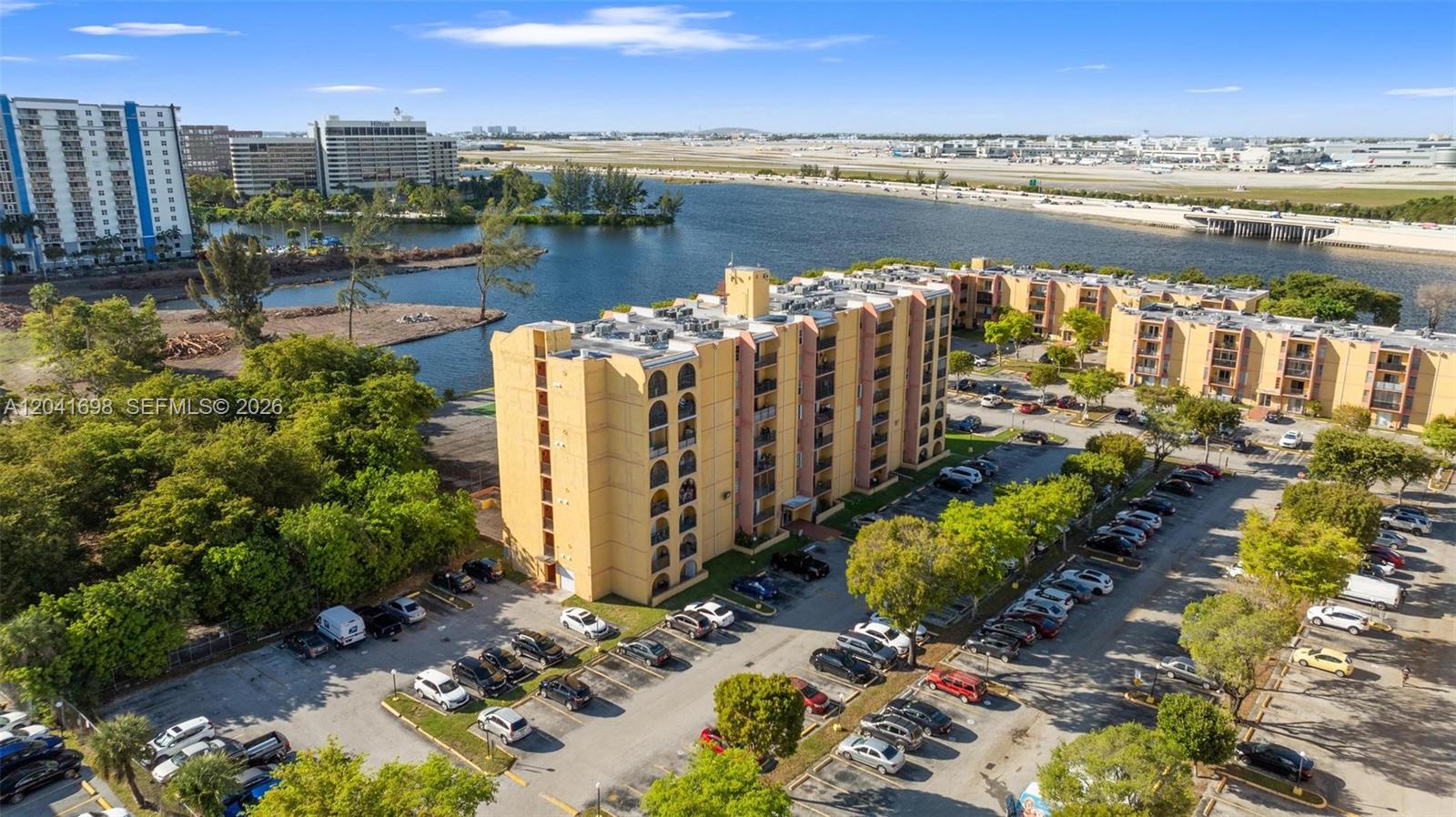 An aerial view shows a multi-story apartment building with a parking lot near a lake — 4801 NW 7th St # 16, Miami FL 33126, MIAMI, FL
