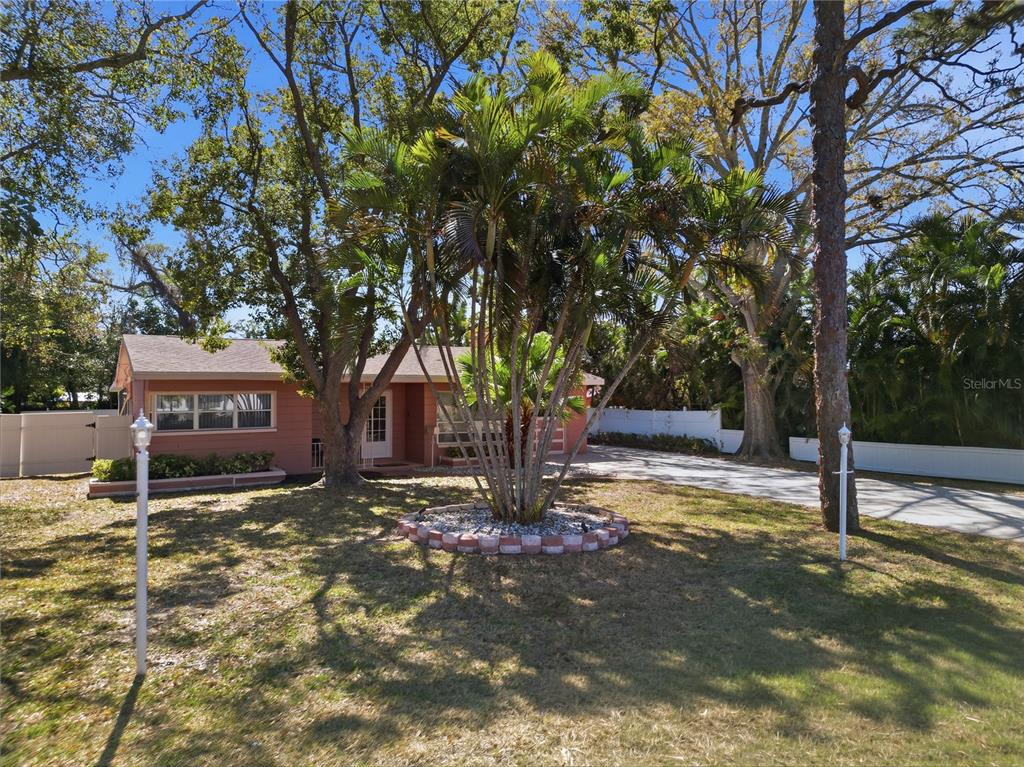 A kitchen features white cabinets, granite countertops, stainless steel appliances, and white marble-look tile flooring — 718 BAY VISTA BOULEVARD S, ST PETERSBURG, FL