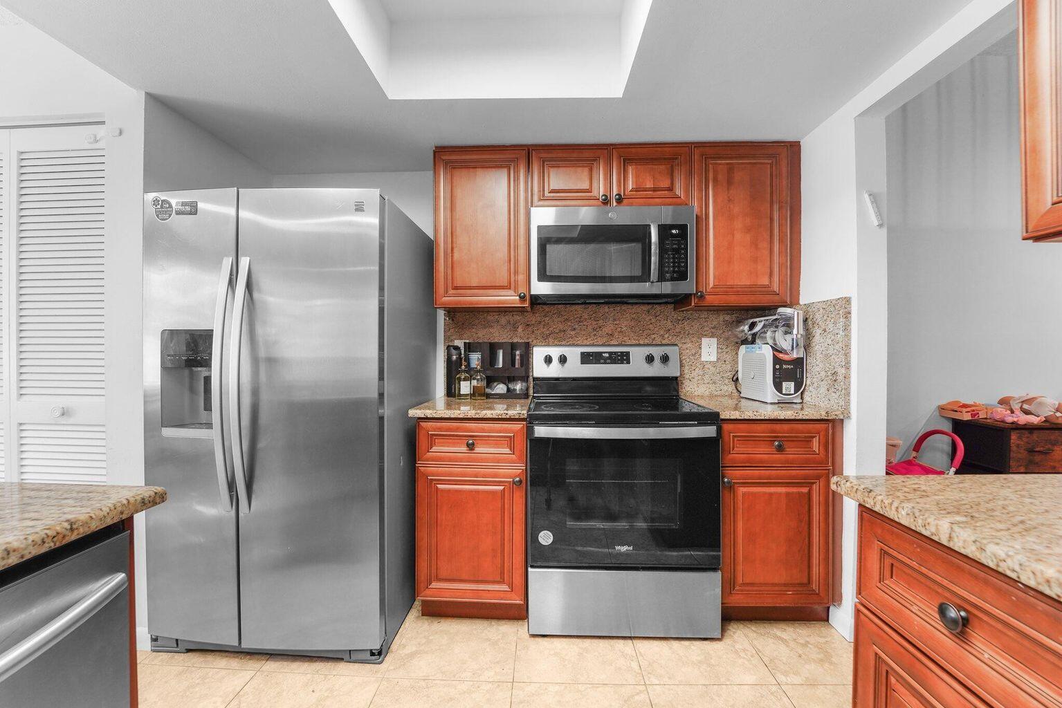 A kitchen featuring stainless steel appliances, wood cabinets, and granite countertops — 6750 Boca Pines Trail # D, Boca Raton FL 33433, BOCA RATON, FL