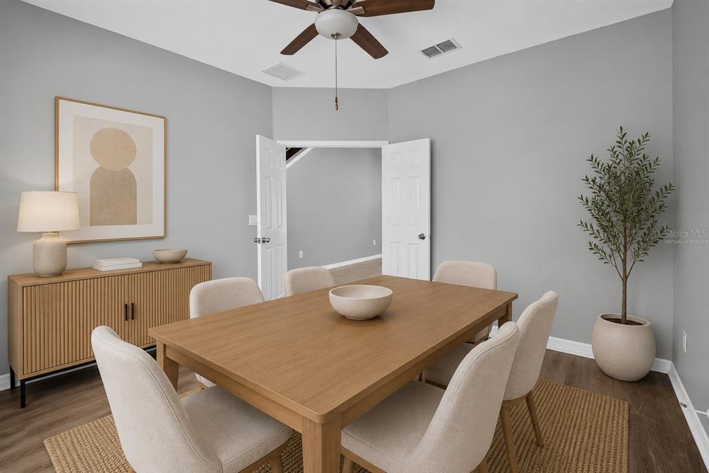 A dining room features a wooden table, six upholstered chairs, a sideboard, and a potted plant — 11144 ANCIENT FUTURES DRIVE, TAMPA, FL
