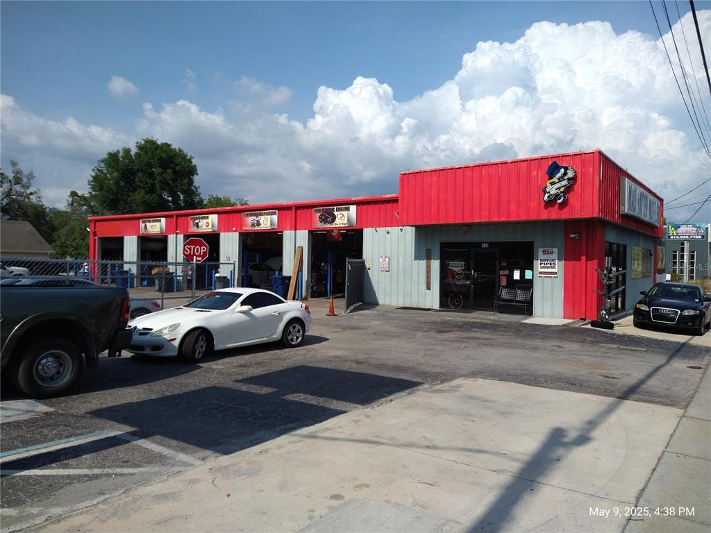 A red and grey commercial auto repair shop features multiple service bays and a parking lot — 715 WEST WATERS AVENUE, TAMPA, FL