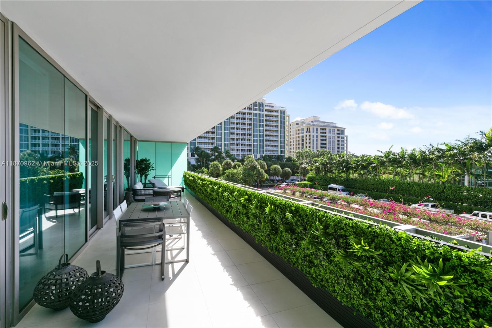 A spacious balcony features a dining set, decorative lanterns, and a lush green privacy hedge — 360 Ocean Dr # 305S, Key Biscayne FL 33149, KEY BISCAYNE, FL