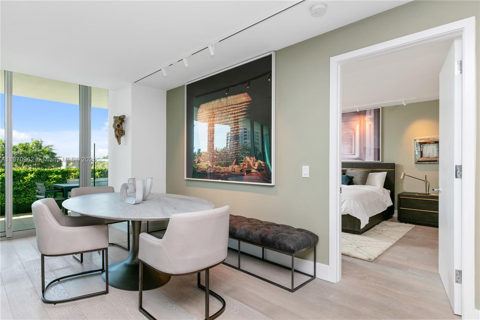 A dining area with a marble table and upholstered chairs sits beside a bedroom doorway — 360 Ocean Dr # 305S, Key Biscayne FL 33149, KEY BISCAYNE, FL