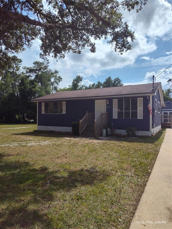 A blue single-story house with white shutters and a small wooden front porch — 140 BAY ROAD, OCKLAWAHA, FL