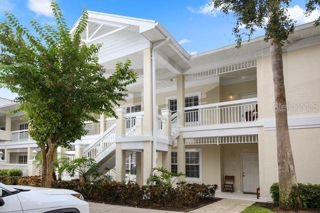 A two-story apartment building with white exterior walls, balconies, and an outdoor staircase — 3706 54TH DRIVE W UNIT 201, BRADENTON, FL
