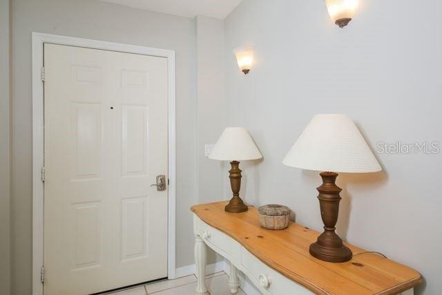 A white door stands next to a wooden console table topped with two lamps — 3706 54TH DRIVE W UNIT 201, BRADENTON, FL