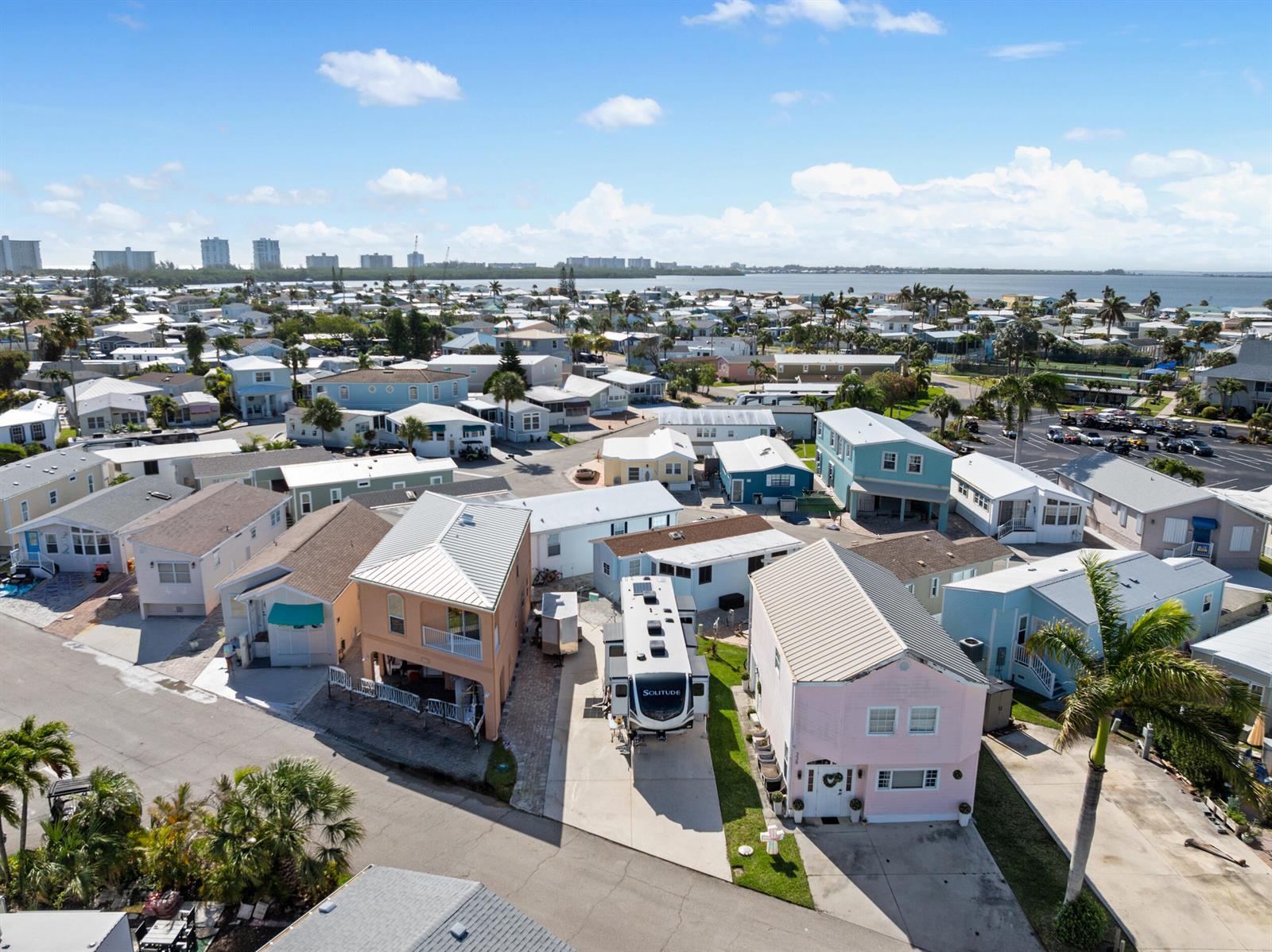 An aerial view shows a residential neighborhood of colorful manufactured homes with a parked RV — 340 Nettles Boulevard, Jensen Beach FL 34957, JENSEN BEACH, FL
