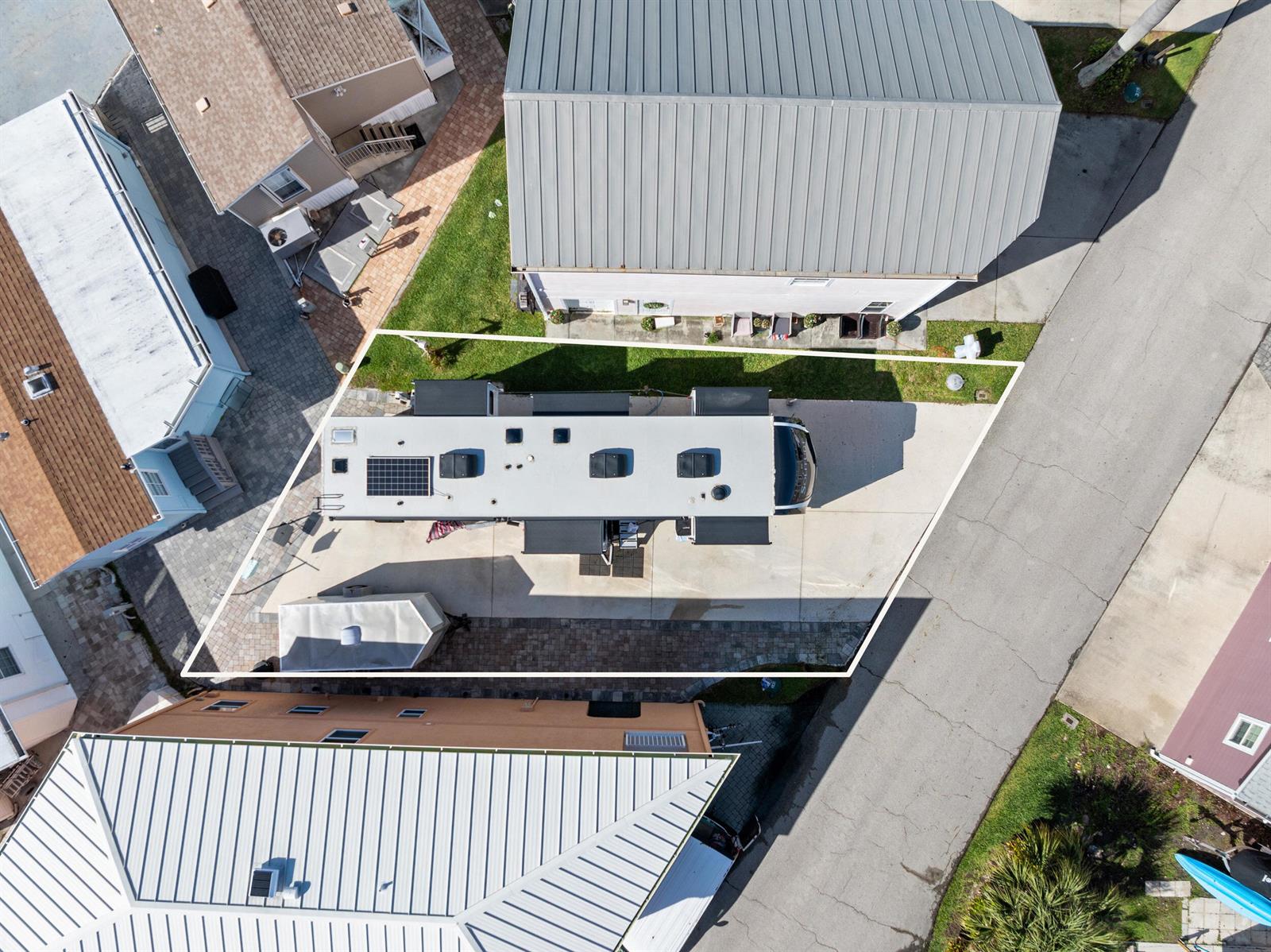 An aerial view shows a recreational vehicle parked on a concrete lot between two buildings — 340 Nettles Boulevard, Jensen Beach FL 34957, JENSEN BEACH, FL