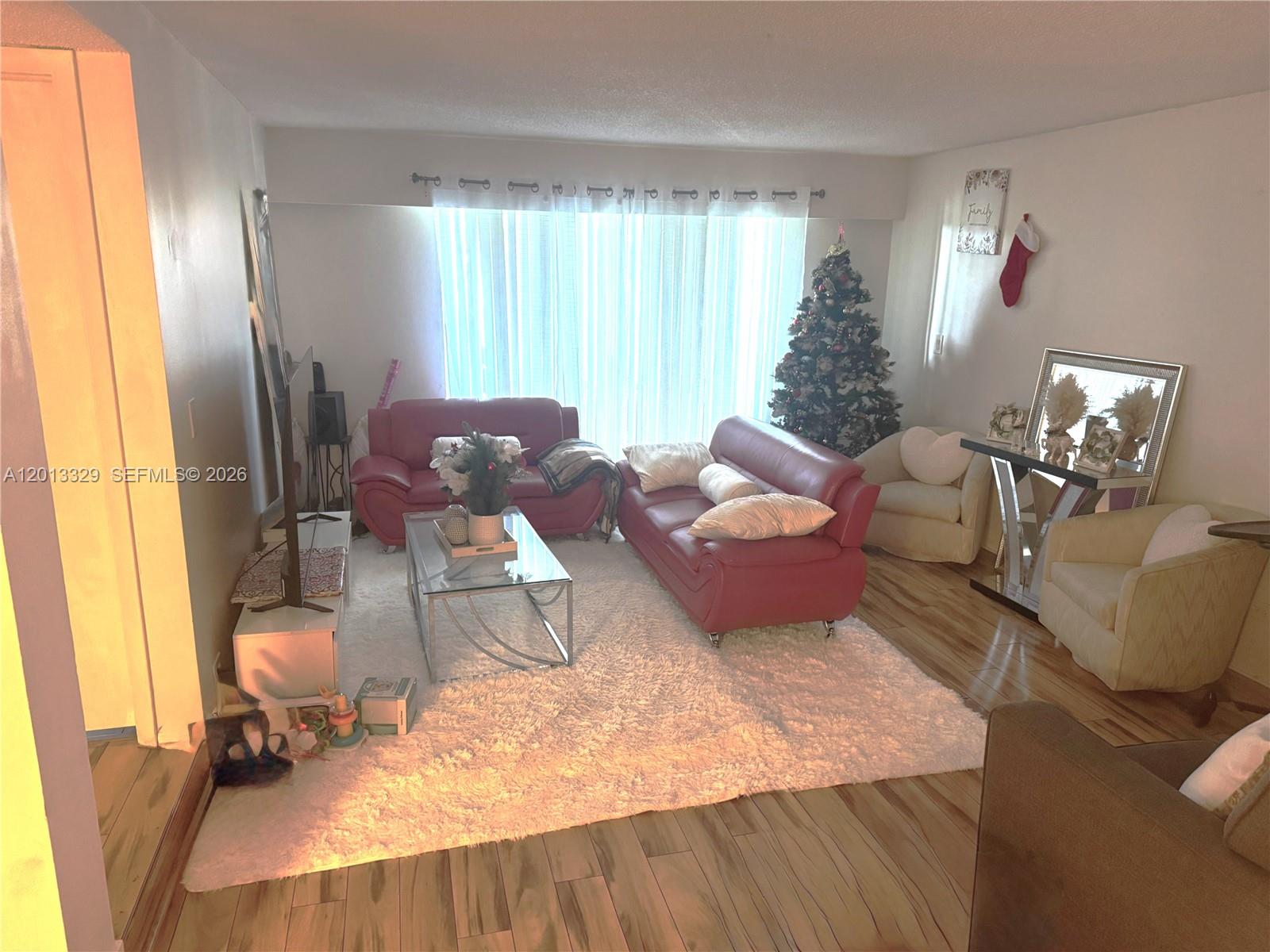 A living room features two red sofas, a white rug, and a Christmas tree — 3740 Inverrary Dr # 2B, Lauderhill FL 33319, LAUDERHILL, FL