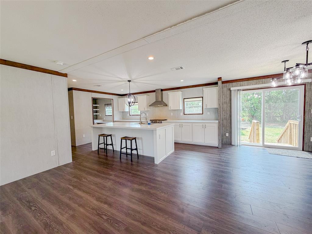 A kitchen with a white island, bar stools, and sliding glass doors leading outside — 330 SW CHALET TERRACE, FORT WHITE, FL