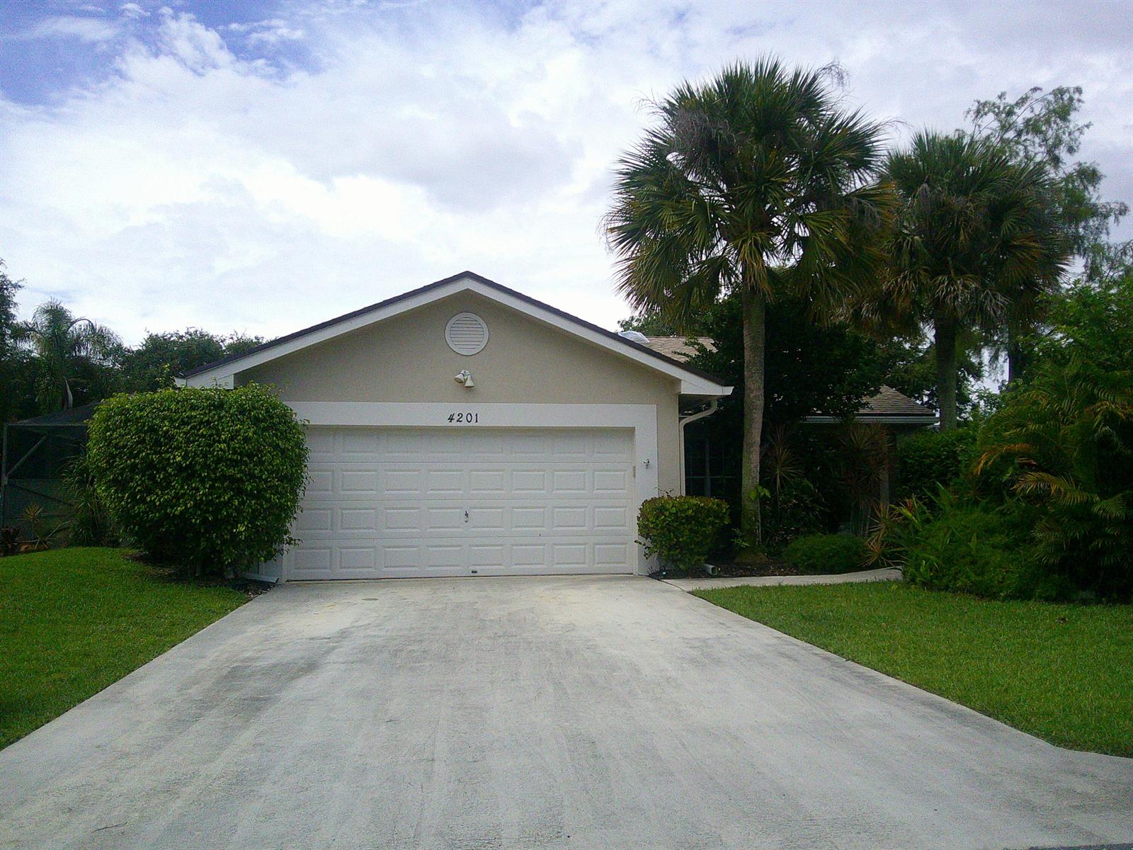 A single-story house with a beige exterior, a white garage door, and palm trees — 4201 Green Forest Way, Boynton Beach FL 33436, BOYNTON BEACH, FL