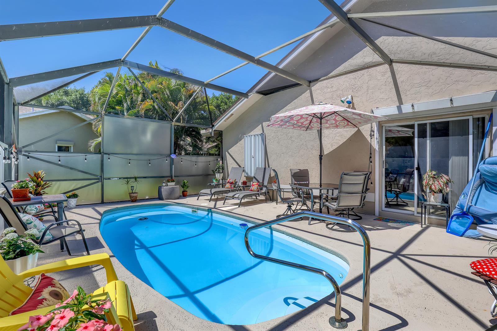 A screened-in patio features a small swimming pool, outdoor furniture, and a patio umbrella — 4201 Green Forest Way, Boynton Beach FL 33436, BOYNTON BEACH, FL