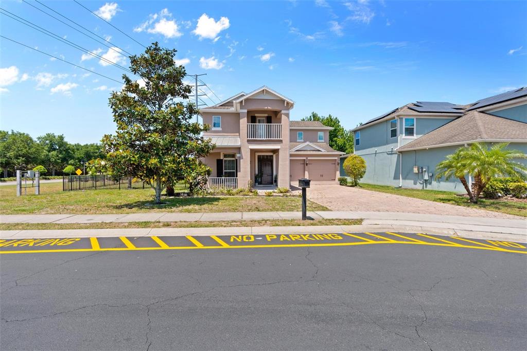 A two-story suburban house with a tan exterior, a front porch, and a paved driveway — 1204 LEXINGTON AVENUE, DAVENPORT, FL