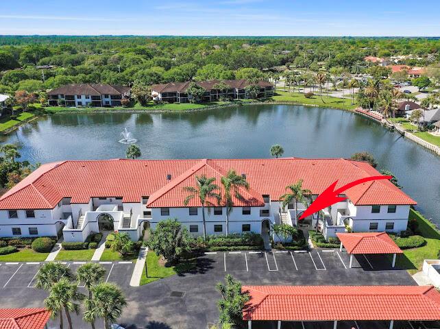 A tiled sunroom with a ceiling fan overlooks a lake and distant buildings at sunset — 6081 SE Landing Way # 6, Stuart FL 34997, STUART, FL