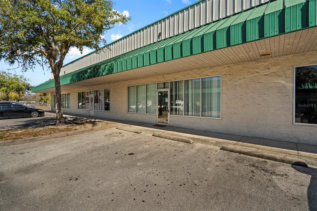 An exterior view of a commercial building with a green awning and parking spaces — 3239 OLD WINTER GARDEN ROAD UNIT 12A/12B, ORLANDO, FL