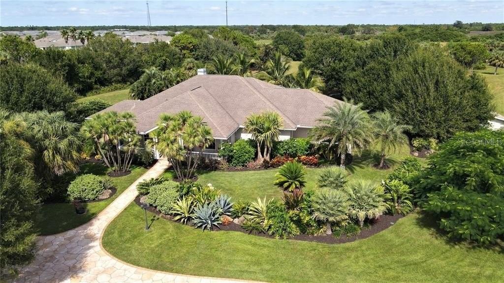 An aerial view of a single-story house surrounded by lush landscaping and palm trees — 3200 ROWLAND DRIVE, PUNTA GORDA, FL