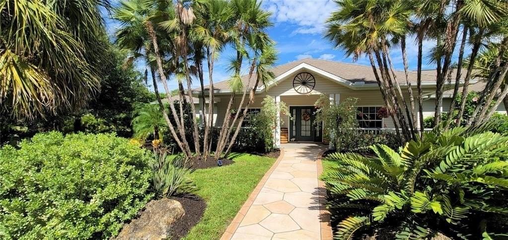 A stone walkway leads to the front entrance of a house surrounded by palm trees — 3200 ROWLAND DRIVE, PUNTA GORDA, FL