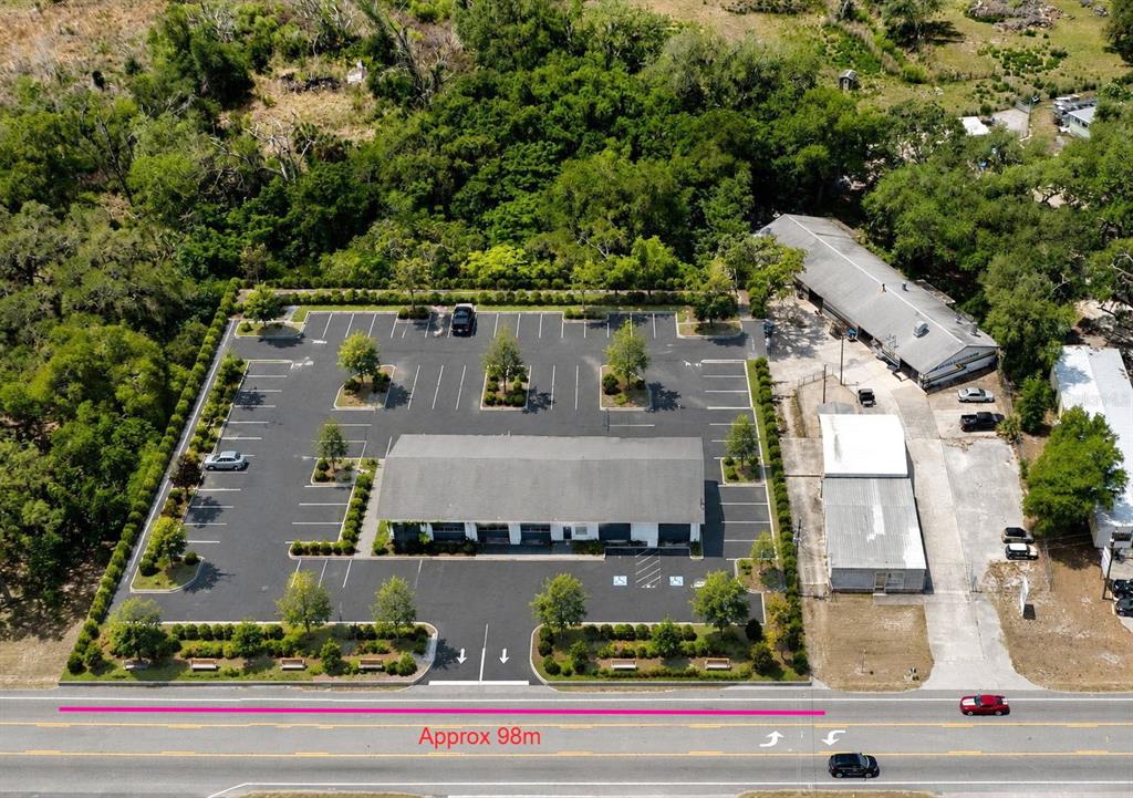 An aerial view shows a commercial building with a large parking lot and landscaping — 70 N FLORIDA AVENUE, INVERNESS, FL