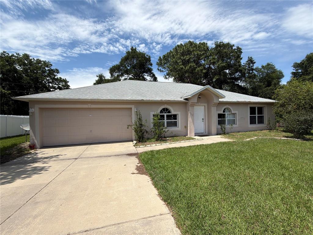 A single-story house with a beige exterior, a two-car garage, and a concrete driveway — 4535 SW 42ND STREET, OCALA, FL