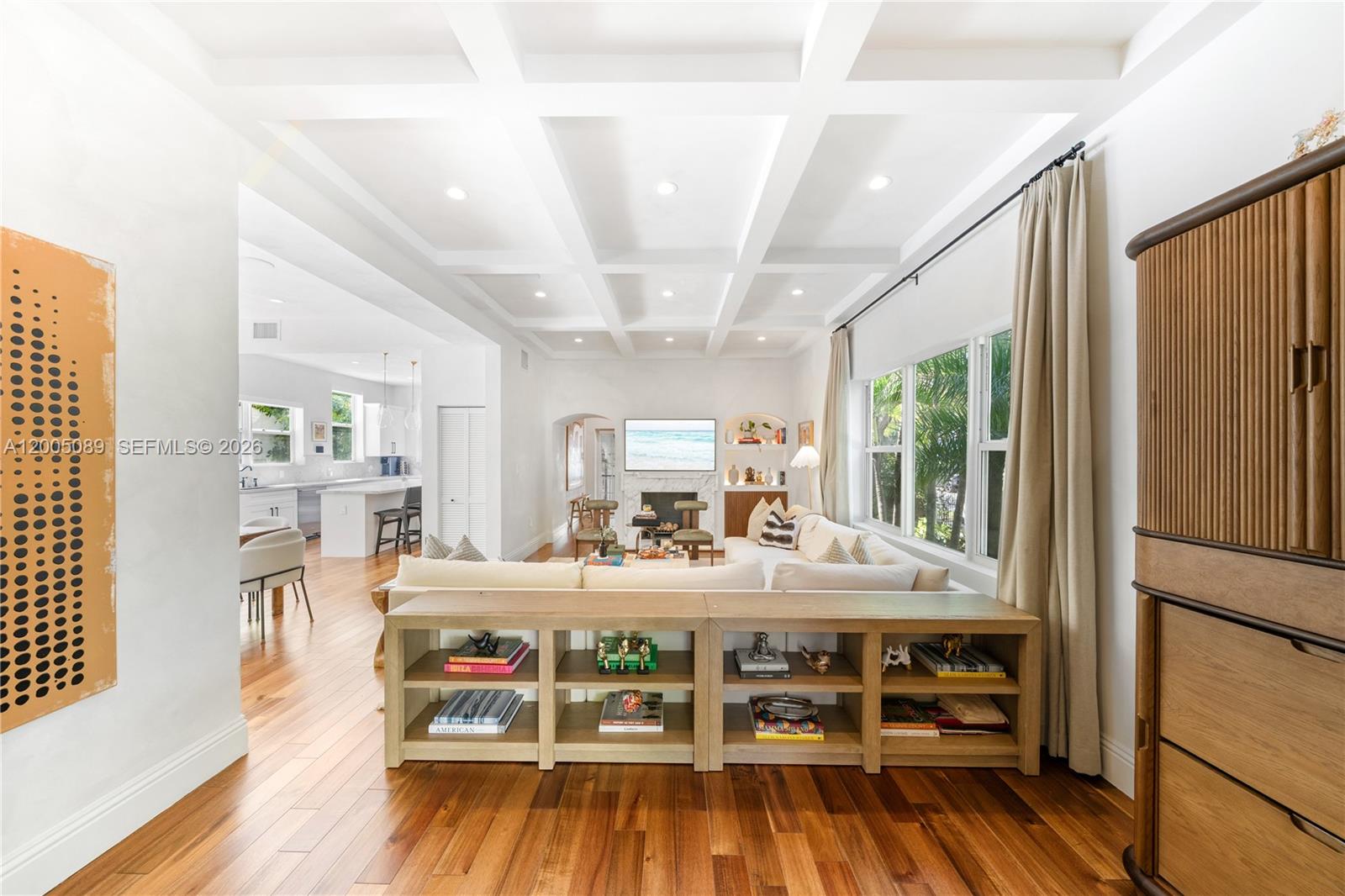 A living room with a coffered ceiling, hardwood floors, and a sofa with a console bookshelf — 130 NE 45th St, Miami FL 33137, MIAMI, FL