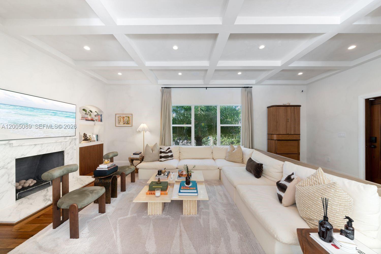 A living room features a coffered ceiling, a marble fireplace, and a large sectional sofa — 130 NE 45th St, Miami FL 33137, MIAMI, FL