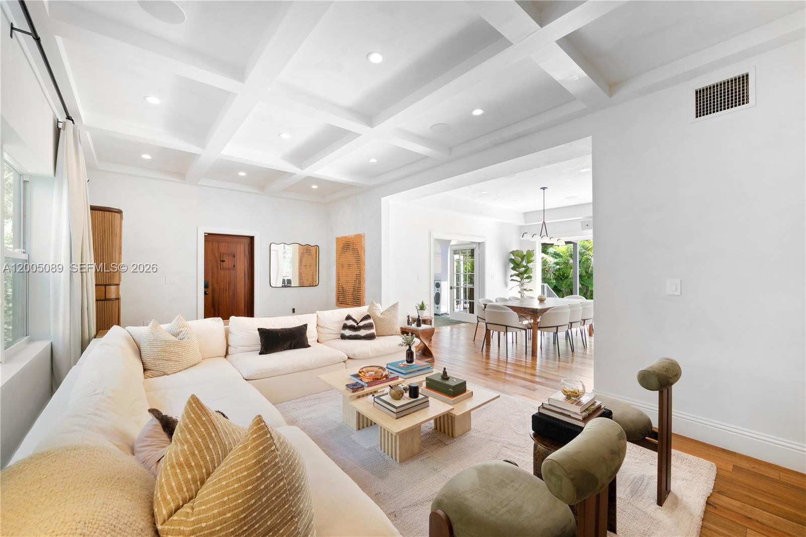 A bright living room features a coffered ceiling, white walls, and an adjacent dining area — 130 NE 45th St, Miami FL 33137, MIAMI, FL