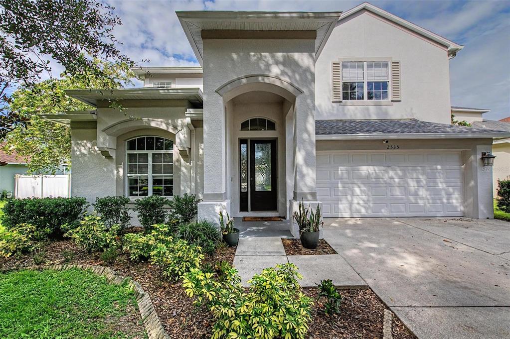 A two-story house with a white stucco facade, arched entryway, and a two-car garage — 2535 CROSS MORE STREET, VALRICO, FL