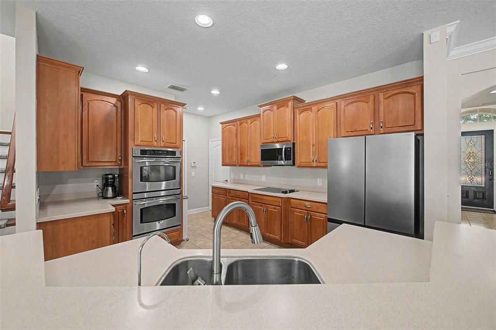 A kitchen features wood cabinets, stainless steel appliances, and a double sink on a peninsula — 2535 CROSS MORE STREET, VALRICO, FL
