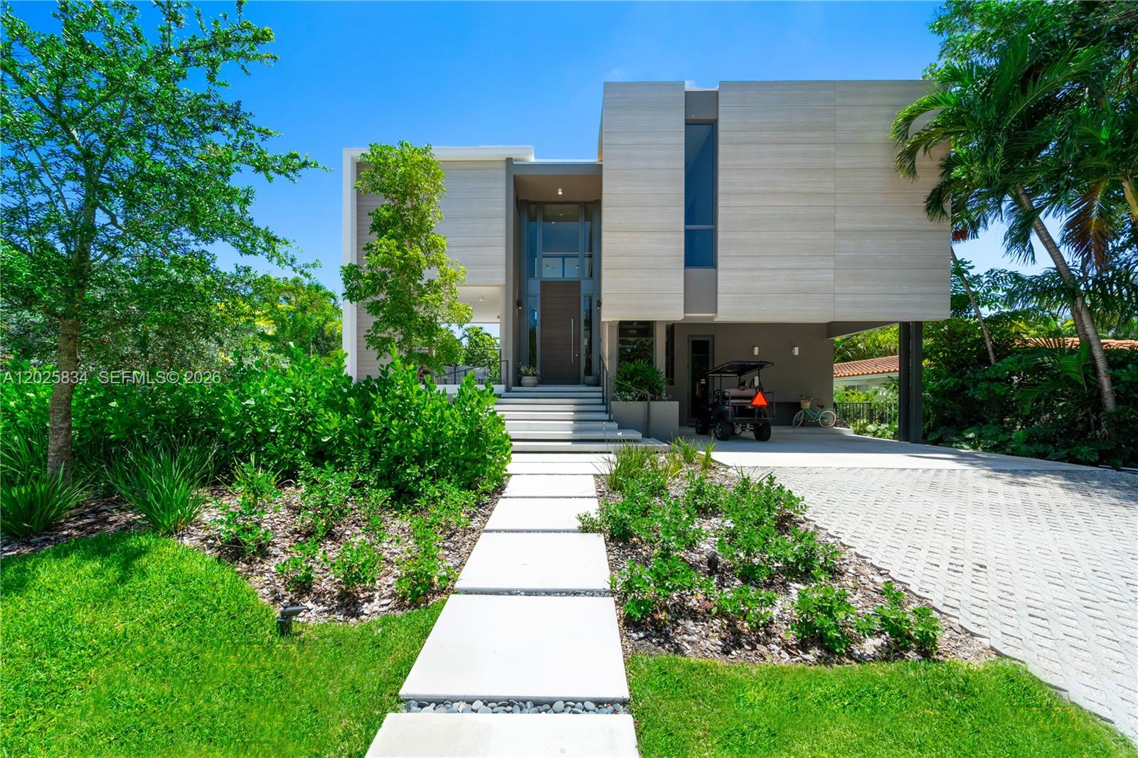 A modern two-story house features a paved driveway, a front walkway, and lush landscaping — 571 Glenridge Rd, Key Biscayne FL 33149, KEY BISCAYNE, FL