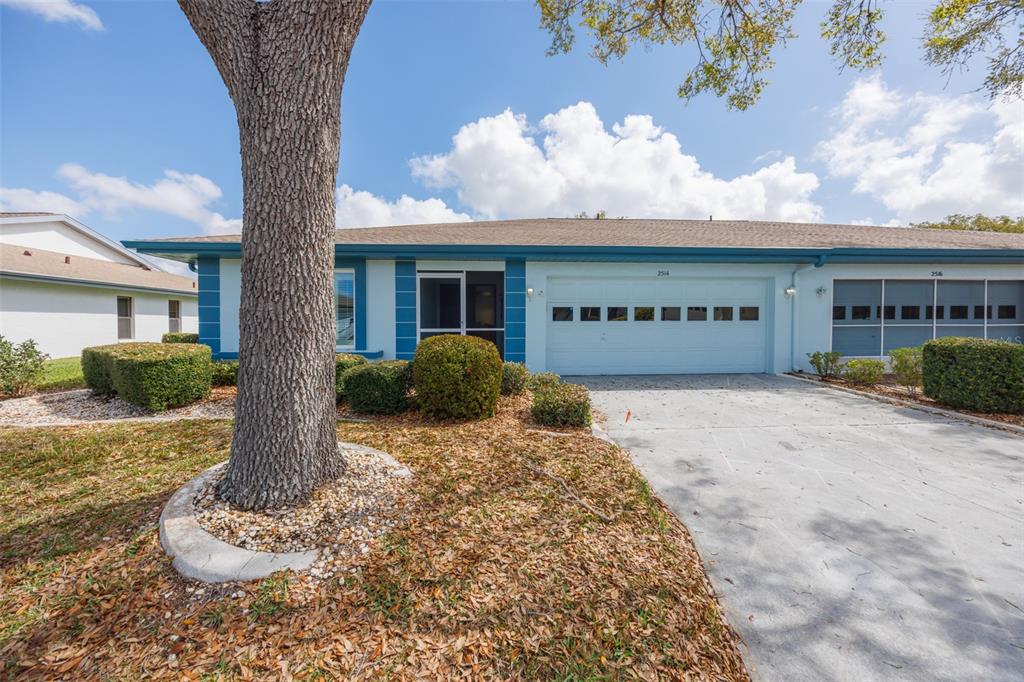 A covered entryway features a blue door with three windows, a ceiling fan, and stone flooring — 2514 LOCKSLEY STREET, SUN CITY CENTER, FL