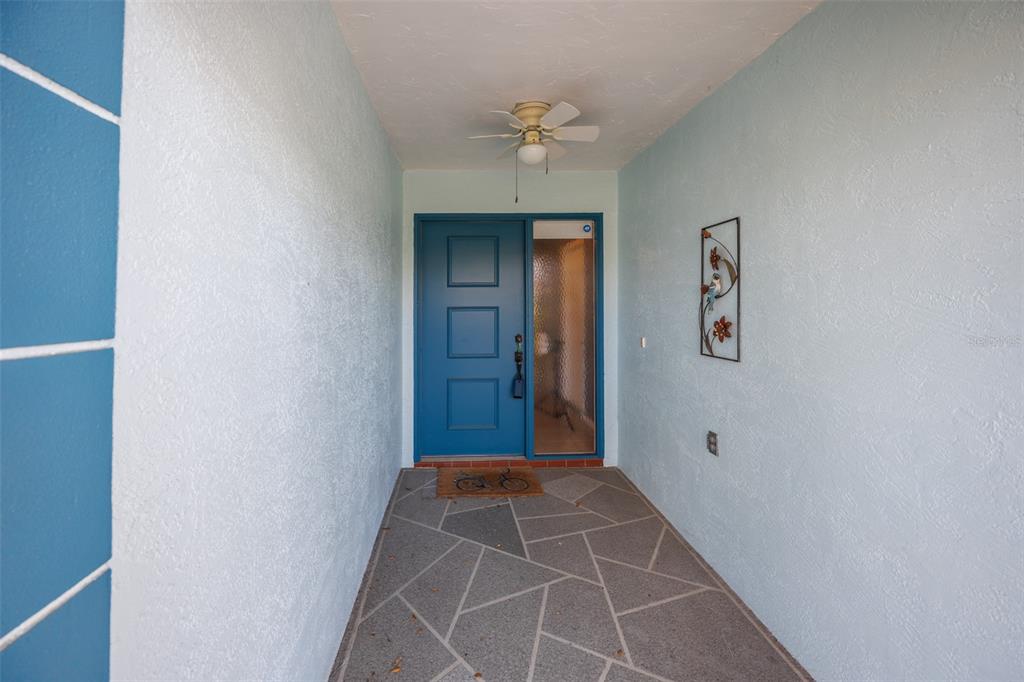 A living room with wood-look flooring, a ceiling fan, and an opening to the kitchen — 2514 LOCKSLEY STREET, SUN CITY CENTER, FL