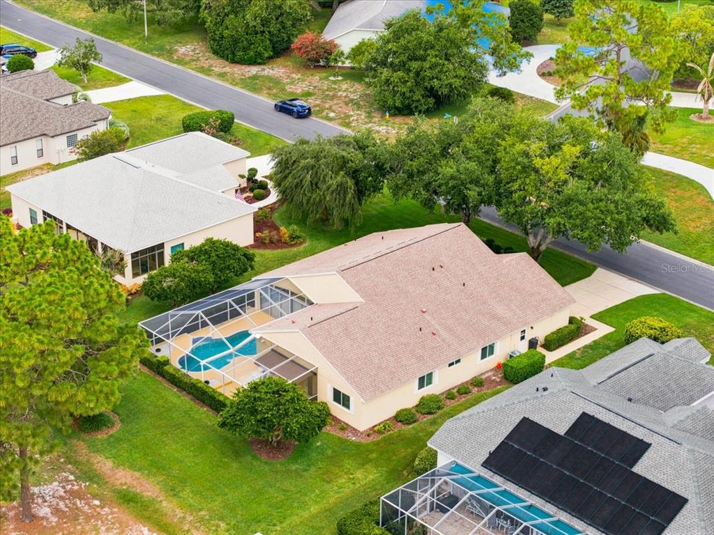 An aerial view shows a suburban house with a screened-in pool and a shingled roof — 9720 SOUTHERN BELLE DRIVE, WEEKI WACHEE, FL