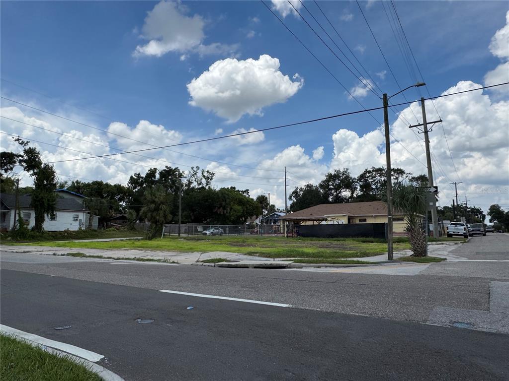 A vacant corner lot with a concrete slab sits beside a street under a cloudy sky — 2804 E COLUMBUS DRIVE, TAMPA, FL
