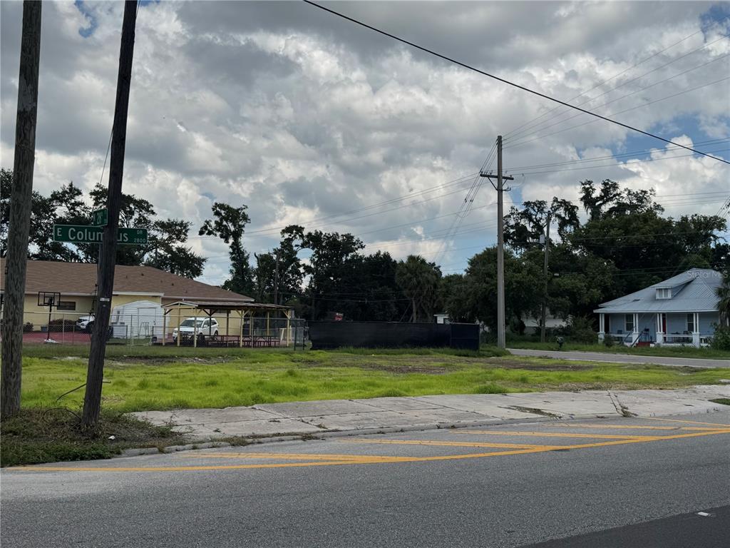 A vacant grassy lot sits at a street corner with a black construction fence — 2804 E COLUMBUS DRIVE, TAMPA, FL