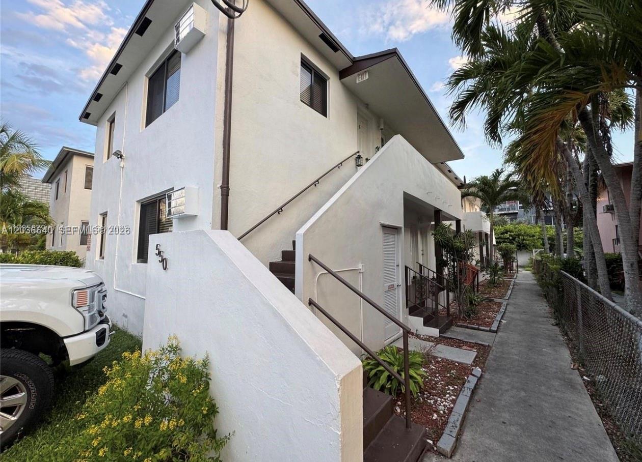 A two-story white stucco apartment building features an exterior staircase and a sidewalk — 550 SW 10th St # 7, Miami FL 33130, MIAMI, FL