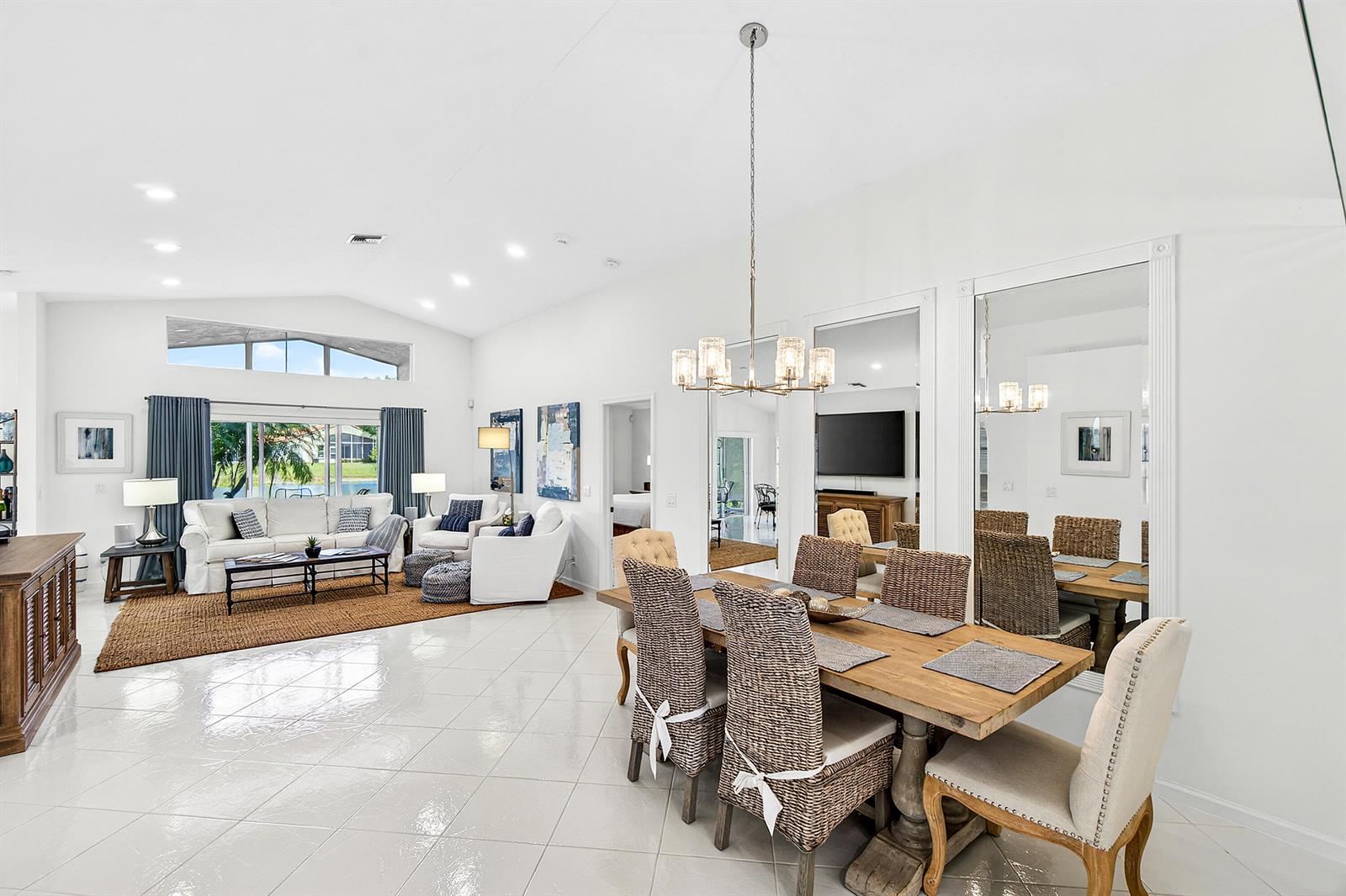 A bright, open-concept living and dining area features white tile floors and vaulted ceilings — 6594 Sun River Road, Boynton Beach FL 33437, BOYNTON BEACH, FL