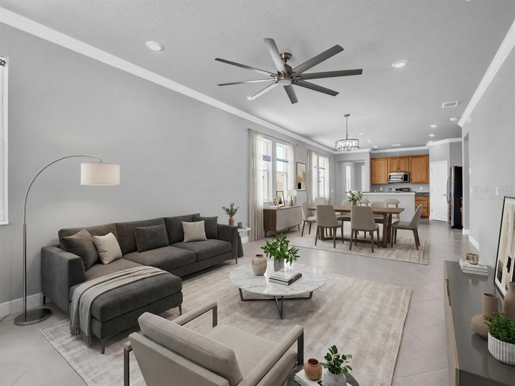 An open-concept living and dining area features a gray sectional, marble coffee table, and kitchen — 1461 N RIVER CIRCLE, TARPON SPRINGS, FL
