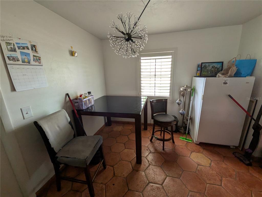 A dining area features a dark square table, two chairs, and a sputnik-style light fixture — 7167 COLUMBIA CIRCLE, FORT MYERS, FL