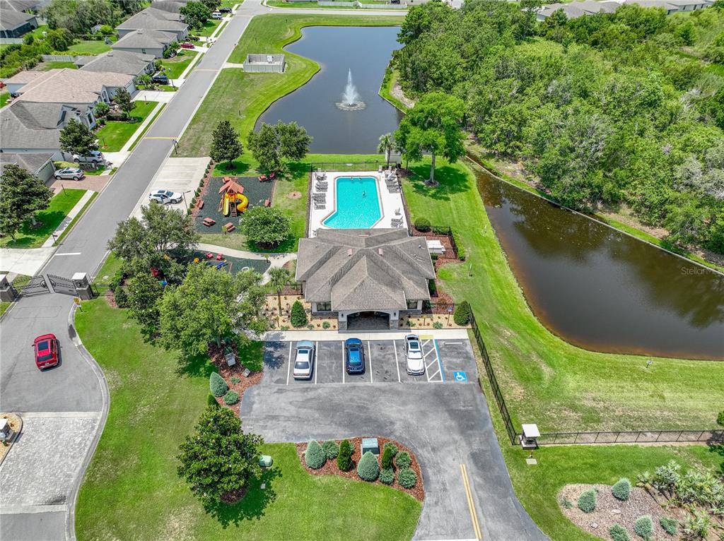 An aerial view shows a community clubhouse with a pool, playground, and two ponds — 1547 CORDGRASS WAY, LAKELAND, FL