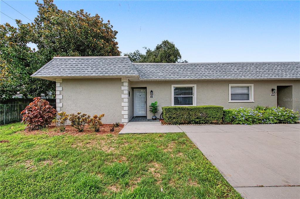 A single-story house with a gray shingled roof, stucco exterior, and a concrete driveway — 3526 TEESIDE DRIVE, NEW PORT RICHEY, FL