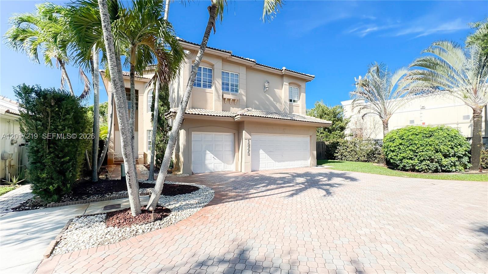 A two-story beige house with a paved driveway and palm trees in the front yard — 10773 NW 73rd Ter, Doral FL 33178, DORAL, FL