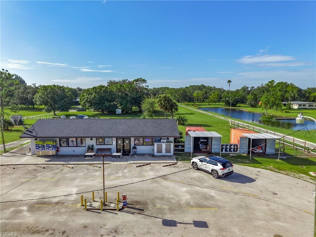 An aerial view shows a single-story commercial building with an adjacent parking lot and pond — OTHER CITY - IN THE STATE OF FLORIDA, FL