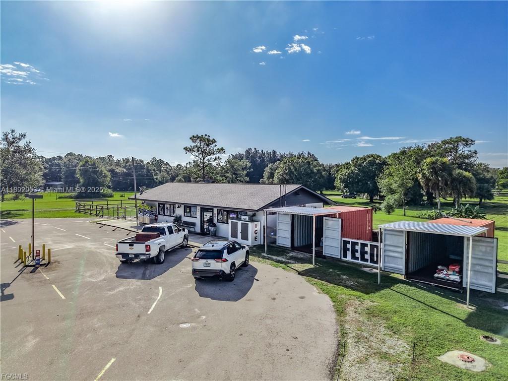 An exterior view shows a commercial building with a parking lot and shipping container storage — OTHER CITY - IN THE STATE OF FLORIDA, FL